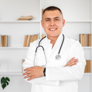 Médico especialista en Medicina Laboral realizando evaluación osteomuscular a trabajador de construcción. El paciente realiza prueba de flexión de columna y movilidad de hombros mientras el médico registra hallazgos en tablet digital.