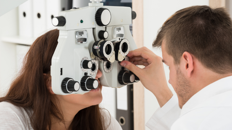 Médico especialista realizando examen de visión a trabajador en consultorio ocupacional